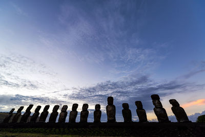 Low angle view of moai at ahu tongariki against sky during sunset