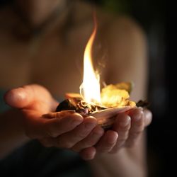 Close-up of hand holding burning outdoors