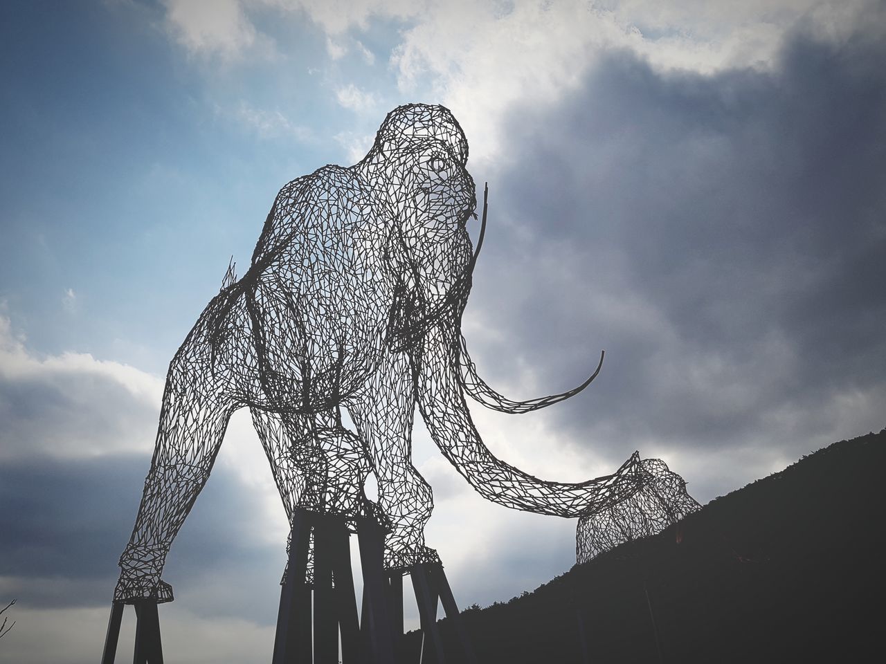 low angle view, animal representation, sculpture, cloud - sky, sky, statue, no people, outdoors, day, carousel