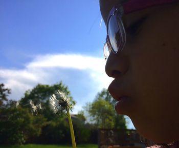 Low angle view of trees against cloudy sky