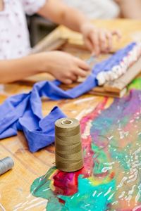 Midsection of woman with painting on table