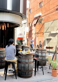 Rear view of people on table against buildings in city