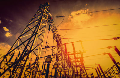 Low angle view of silhouette cranes against sky during sunset