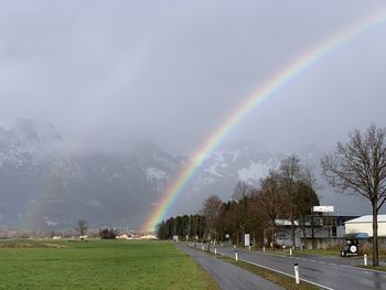Scenic view of rainbow over trees against sky