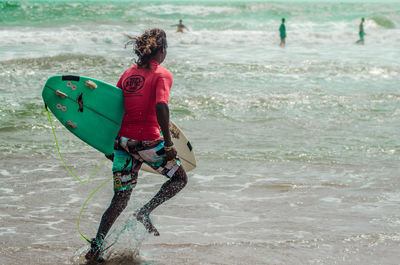 Rear view of man surfing in sea