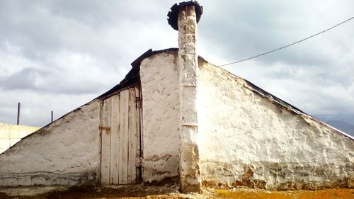 Low angle view of built structure against cloudy sky