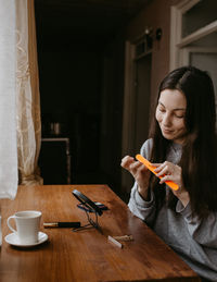 Young woman using mobile phone at home