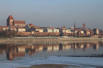 River by buildings against sky in city