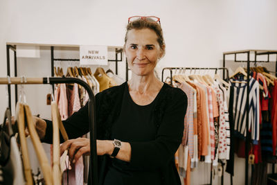 Portrait of a smiling young woman standing in store