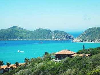 Scenic view of sea and mountains against clear sky