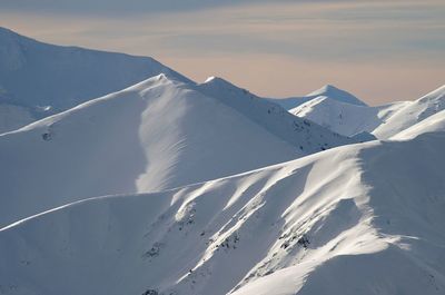 Scenic view of snow covered mountains against sky