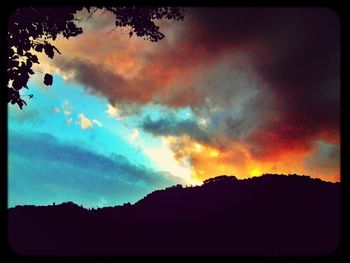 Silhouette of landscape against cloudy sky