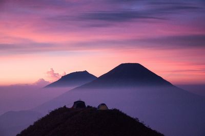 Scenic view of silhouette mountains against sky at sunset