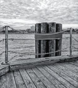 Wooden posts on beach against sky