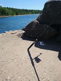 Shadow on rock by sea against sky