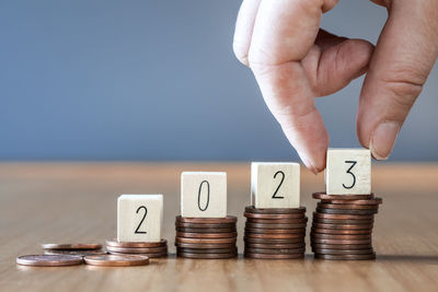 Cropped hand stacking coins on table