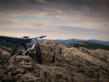 Mountain bike on rock against sky