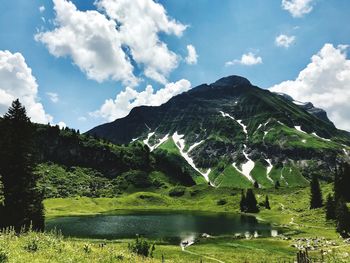 Scenic view of lake by mountains against sky