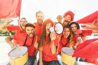 Portrait of fans screaming outdoors