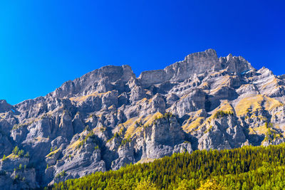 Scenic view of mountains against clear blue sky