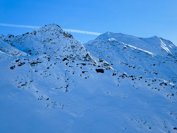Mountains with dark rocks peeking through the snow