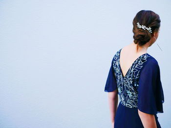 Young woman standing against gray background