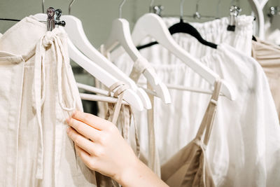 Sustainable fashion, slow fashion. close up shot of female hand taking clothing rack with natural