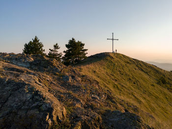 Scenic view of big cross and mountains against clear sky