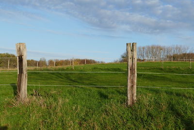 Wooden fence on field against sky