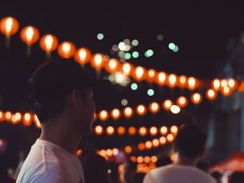 Defocused image of illuminated man standing at night