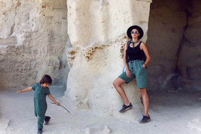 Mother and son travelers walk near a rock in the crimea