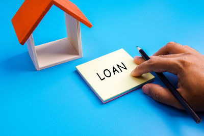 Midsection of person holding text against blue background