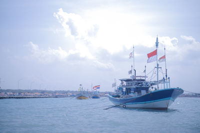 Sailboat moored on sea against sky