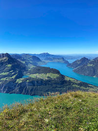 Scenic view of lake and mountains against blue sky