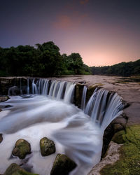Scenic view of waterfall against sky