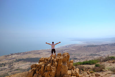 Woman on beach against clear blue sky