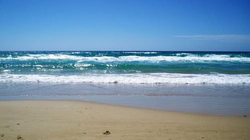 Scenic view of beach against blue sky