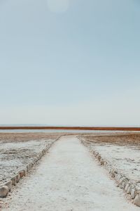 Dirt footpath on field against clear sky at atacama desert