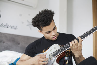 Young man playing an electric guitar