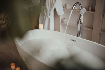 Luxury interior of big bathroom at modern african style with oval bathtub in natural lighting