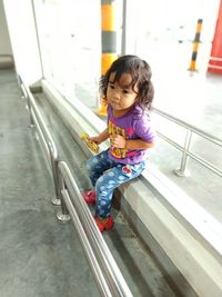 Full length of cute girl sitting outdoors