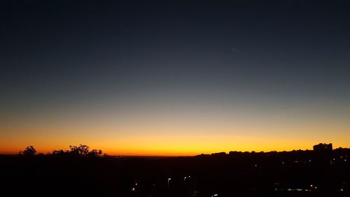 Scenic view of silhouette landscape against orange sky
