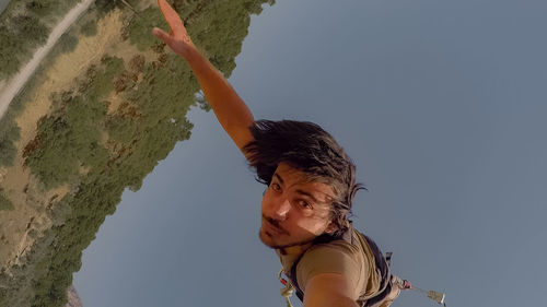 Low angle portrait of woman against sky