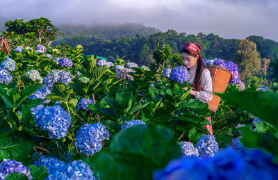 Portrait of beautiful young woman on flowering plants