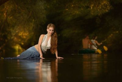 Portrait of woman sitting in lake