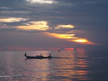 Boat sailing in sea at sunset