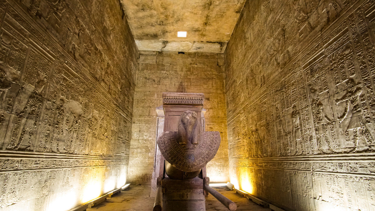 STATUE AMIDST ILLUMINATED BUILDING