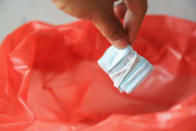 Close-up of human hand holding red paper
