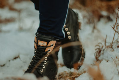 Low section of person standing on snow