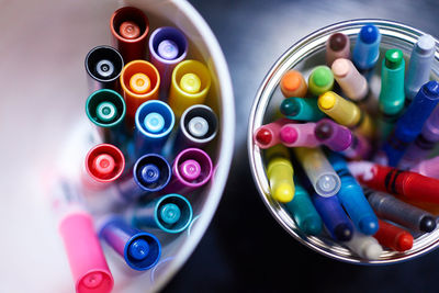 High angle view of colored pens in container